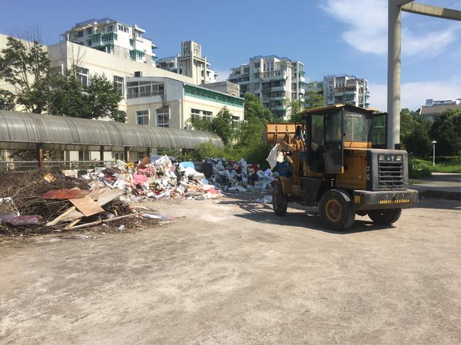 小区正在清运建筑垃圾零时堆放点的建筑垃圾.